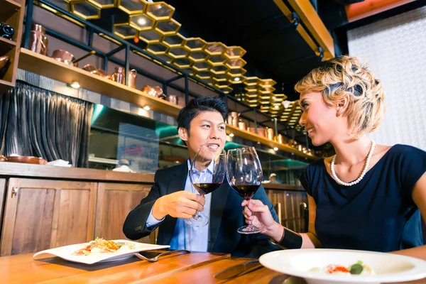 Asiatisches Paar stößt mit Rotwein an — Stockfoto