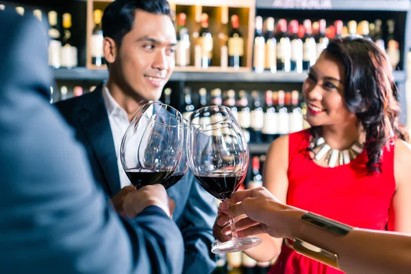 Asiático amigos brindar com vinho tinto no bar — Fotografia de Stock