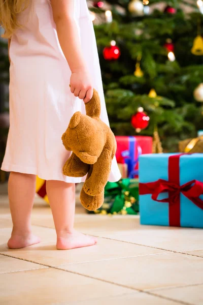 Meisje met heden en teddy op eerste kerstdag — Stockfoto