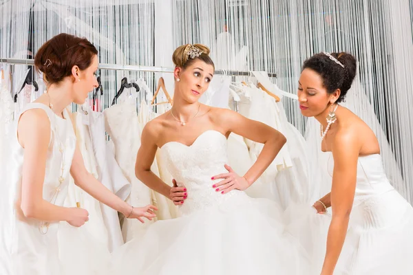 Женщины веселятся во время примерки свадебного платья в магазине Стоковая Картинка