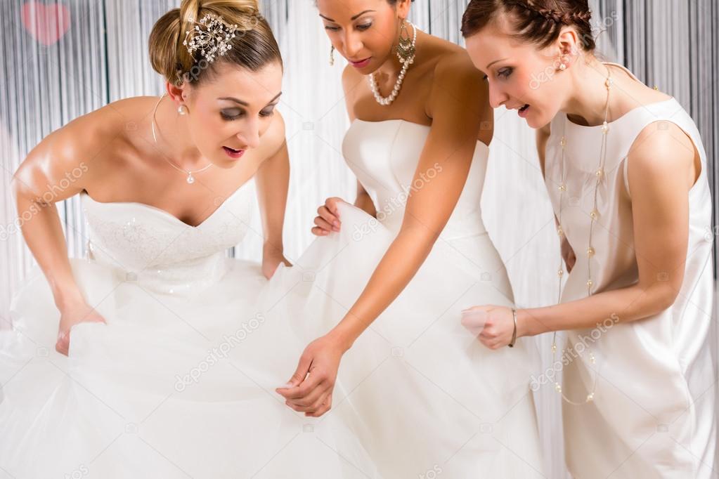 Brides at wedding dress fitting in shop