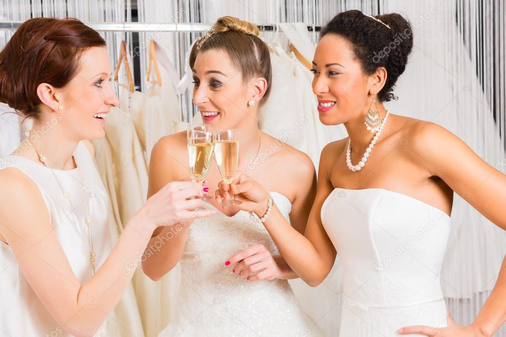 Brides drinking champagne in wedding shop