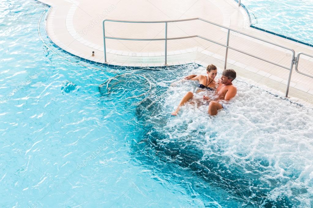 Couple in thermal wellness spa on water massage