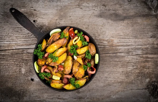 Batatas fritas com salsichas na mesa de madeira — Fotografia de Stock