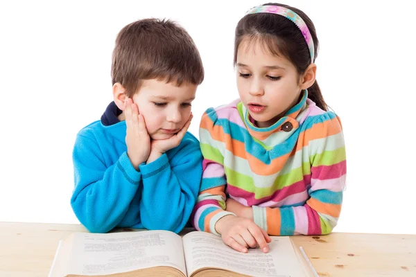 テーブルで本を読んで二人の子供 ロイヤリティフリーのストック画像