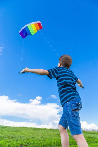 緑の丘の上のカラフルな凧と少年 — ストック写真