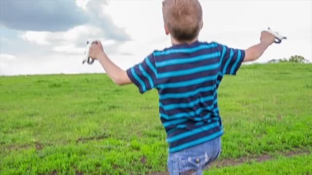 Jongen met kleurrijke kite op de groene heuvel — Stockvideo