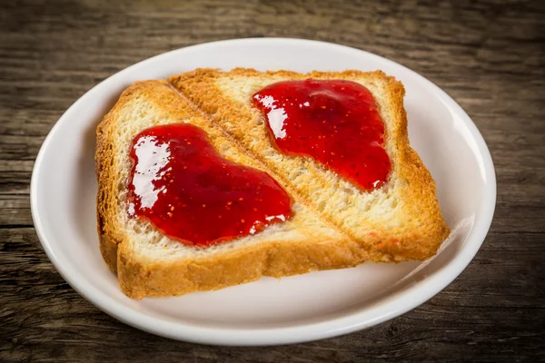 Toast mit Erdbeermarmelade auf einem Teller — Stockfoto