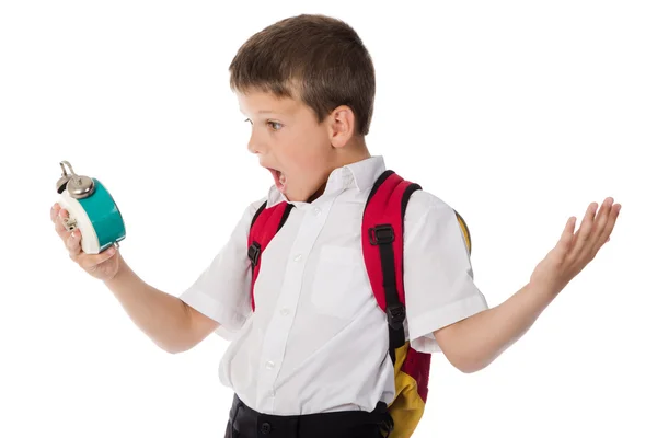 Surprised schoolboy with alarm clock in hand — Stock Photo, Image