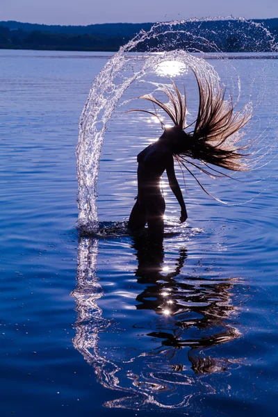 Silhouette della giovane ragazza negli spruzzi d'acqua — Foto Stock