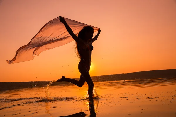Silhouette di ragazza che corre sulla spiaggia — Foto Stock