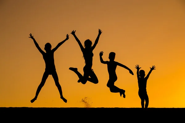 Sylwetka skoki dzieci przeciwko zachód słońca — Zdjęcie stockowe