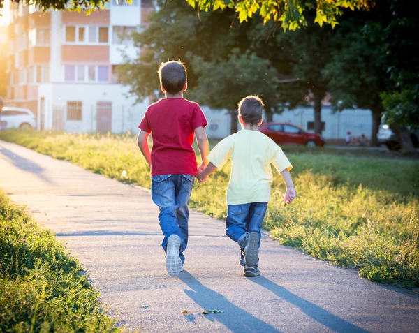 Два мальчика бегут вместе по улице — стоковое фото