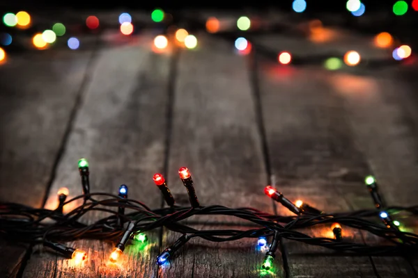 Luces de Navidad sobre fondo de madera oscura — Foto de Stock