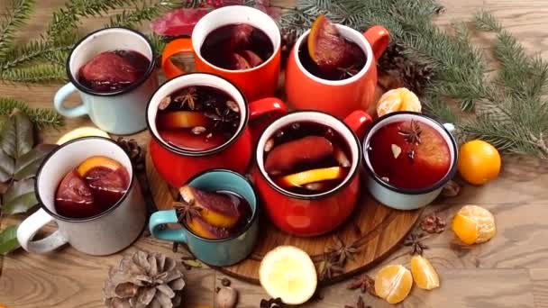 Много красочных чашек с глинтвейном на праздничном столе — стоковое видео