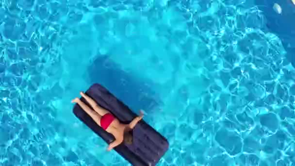 Boy lying on inflatable mattress in the swimming pool, aerial view — Stock Video