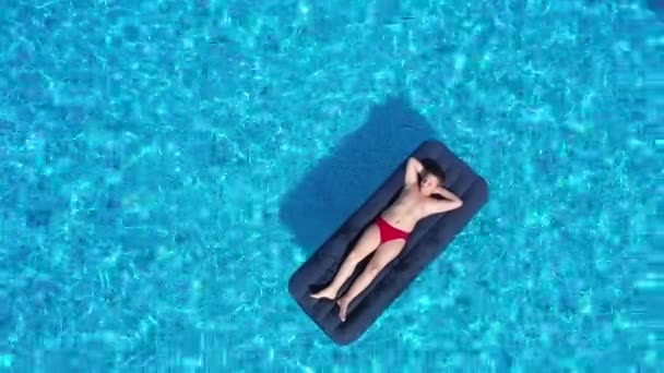 Chłopiec leżący na dmuchanym materacu w basenie, widok z powietrza — Wideo stockowe