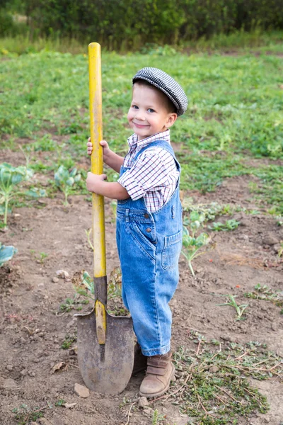 Kleiner Junge mit Schaufel auf Feld — Stockfoto