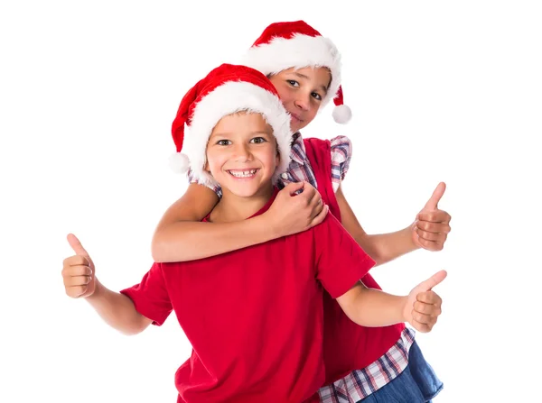 Двое детей в рождественских шляпах вместе — стоковое фото