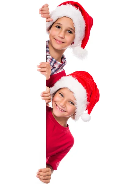 Crianças em chapéu de Santa com quadro branco — Fotografia de Stock