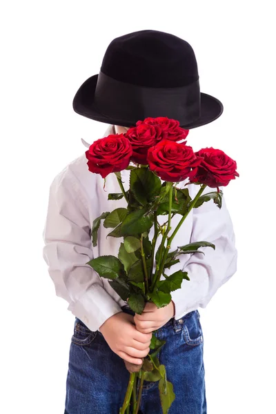 Schüchterner kleiner Junge mit roten Rosen Stockbild