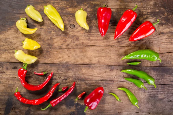 Pimentas coloridas na mesa de madeira — Fotografia de Stock