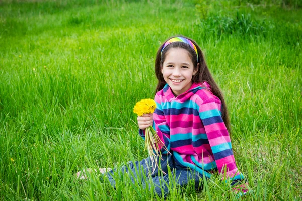 Girl on field with bouquet of dandelions — Stock Photo, Image