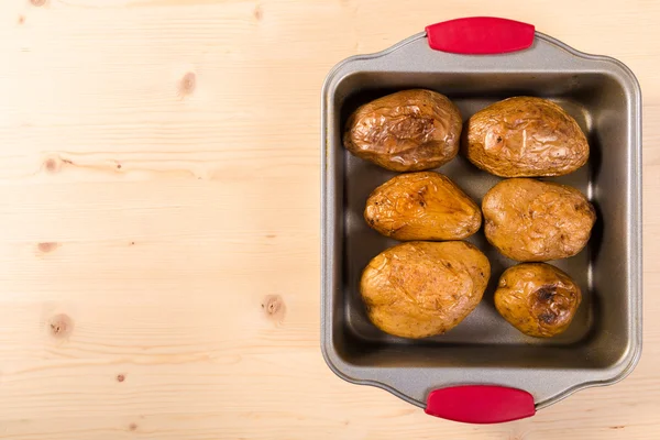 Baked potatoes in tray with copy space — Stock Photo, Image