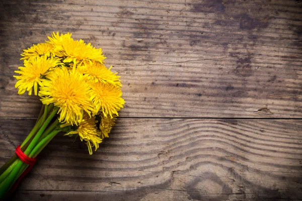 Dandelions na textura de madeira marrom — Fotografia de Stock