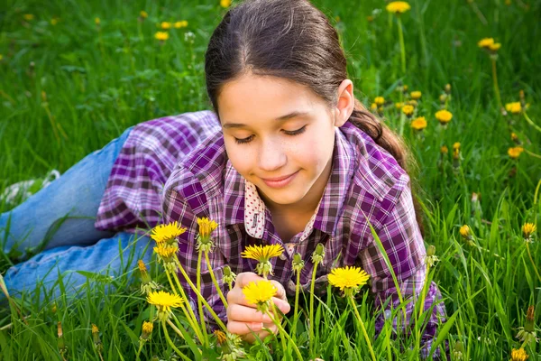 Cute girl on field with dandelions — Stock Photo, Image