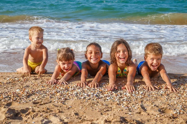 Fem unger på stranda. – stockfoto