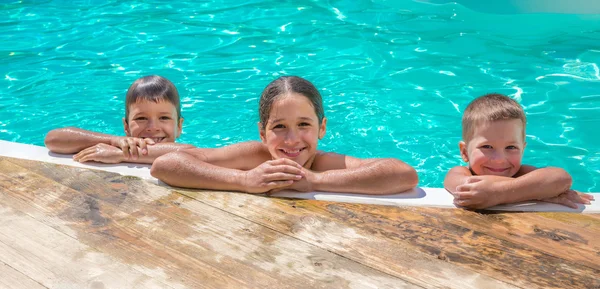 Trois enfants se relaxant sur la piscine — Photo