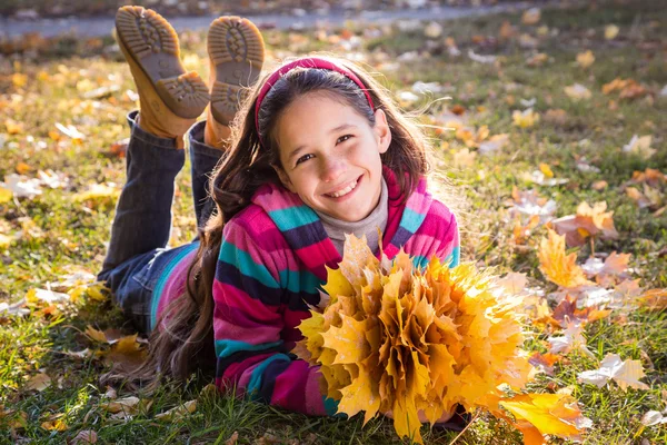 Fille souriante avec des feuilles d'automne — Photo