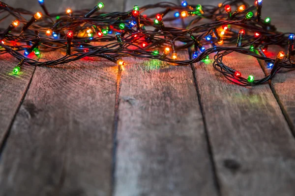 Luces de Navidad sobre fondo de madera — Foto de Stock