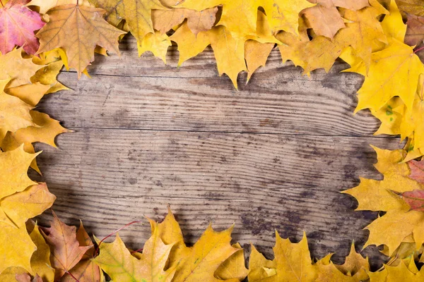 Fondo in legno con foglie gialle — Foto Stock