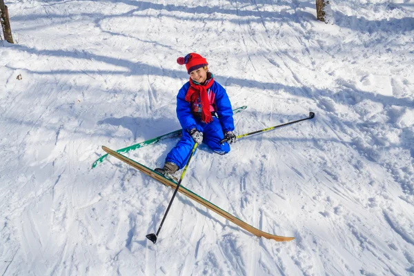 Girl sitting down on the snow learning skiing — Stock Photo, Image