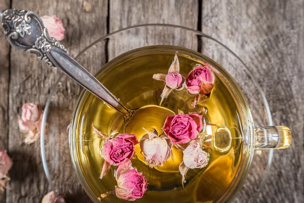 Närbild av grönt te kopp med torkade rosor — Stockfoto