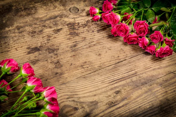 Μάτσο ροζ τριαντάφυλλα σε φόντο ξύλου — Φωτογραφία Αρχείου