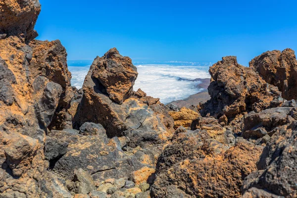 Banco de niebla detrás de rocas volcánicas — Foto de Stock