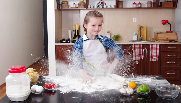 little girl is helping to bake  in a messy  kitchen