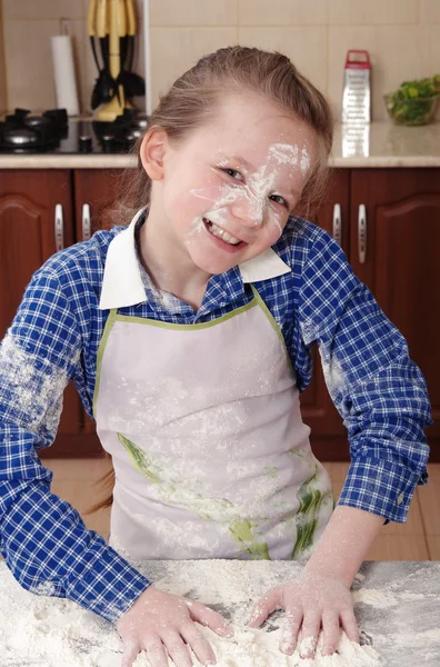 little girl is helping to bake  in a messy  kitchen