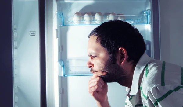 Hombre divertido mirando en el refrigerador — Foto de Stock