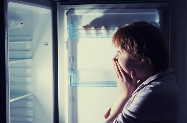 Mujer sorprendida mirando en el refrigerador —  Fotos de Stock