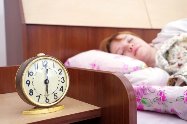 Mujer y despertador en el dormitorio — Foto de Stock