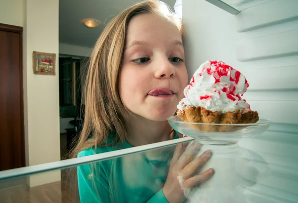 Chica ve el dulce pastel en la nevera —  Fotos de Stock