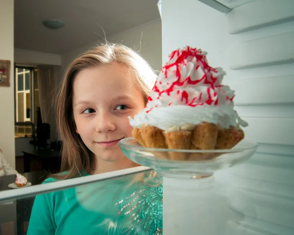 Ragazza vede la torta dolce in frigorifero — Foto Stock