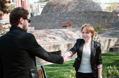 Genç iş adamı ve kadın el sıkışıyor.