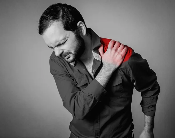 Vousatý muž má bolest ramene — Stock fotografie