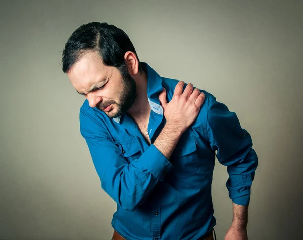 Homem barbudo tem uma dor no ombro — Fotografia de Stock
