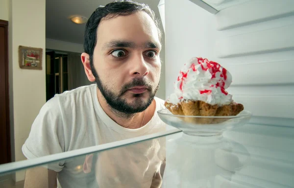 Homem engraçado vê o bolo doce na geladeira — Fotografia de Stock